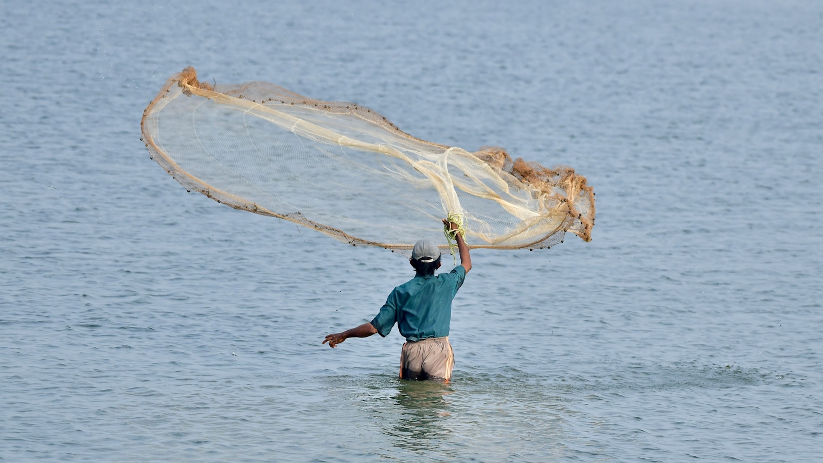 a man wading in the water with a fishing net